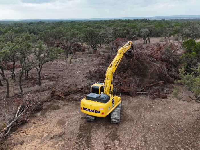 Cedar Eater excavator pulling apart large burn piles in Mills County TX